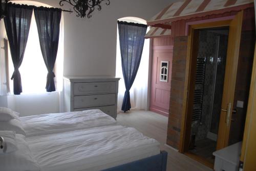 a bedroom with a bed and a dresser and a mirror at Régi Posta Hotel és Étterem in Debrecen