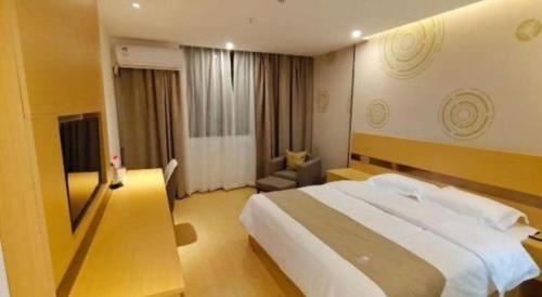 a hotel room with a large bed and a couch at GreenTree Inn Linhai Jiangnan Avenue Express in Linhai