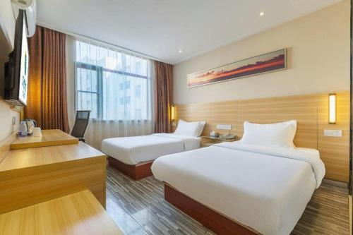une chambre d'hôtel avec deux lits et un bureau dans l'établissement City Comfort Inn Nanchang Bayi Square Metro Station Wushang, à Nanchang