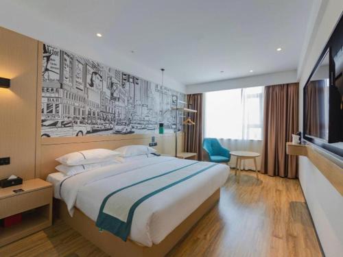 ein Hotelzimmer mit einem großen Bett und einem Fernseher in der Unterkunft City Comfort Inn Tonglu Fuchun River Qiaolin Road in Tonglu