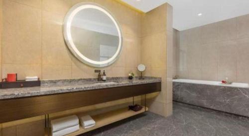 a bathroom with a sink and a tub and a mirror at E-Cheng Hotel Yangjiang Baili Plaza in Yangjiang
