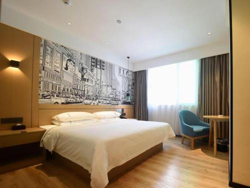 a bedroom with a large bed and a blue chair at City Comfort Inn Qingyuan Longtang Light Rail Changlong in Qingyuan