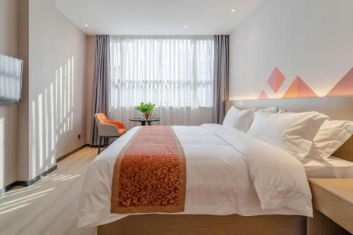 a bedroom with a bed and a desk and a window at Borrman Hotel Hefei Yaohai Wanda Linquan East Road in Hefei