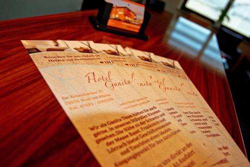 a menu for a restaurant on a table at Hotel Ganita Weil am Rhein in Weil am Rhein