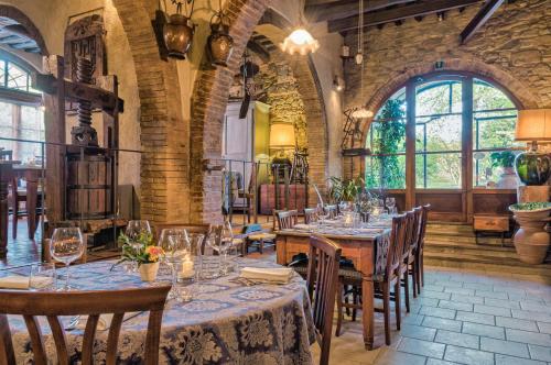 a dining room with tables and chairs and windows at Borgo San Benedetto in Montaione