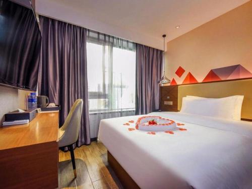 a hotel room with a large bed and a desk at Borrman Hotel Guangzhou Railway Station Yuexiu Park Memorial Hall in Guangzhou
