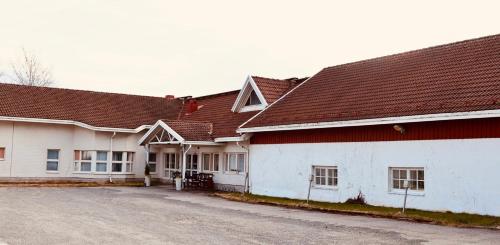 a white building with a red roof at Hotelli Unelma in Kullaa