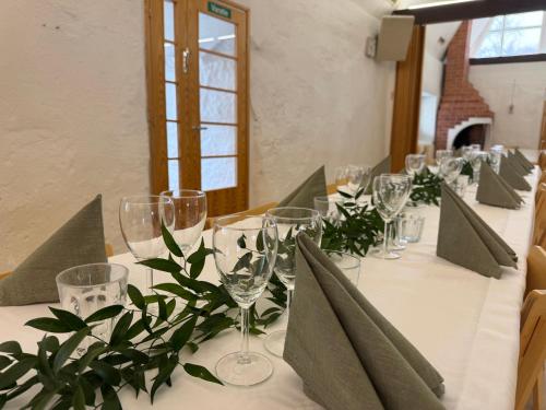a long table with wine glasses and plants on it at Hotelli Unelma in Kullaa
