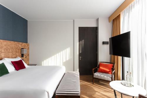 a hotel room with a bed and a chair at Debaines Hotel Santiago in Santiago