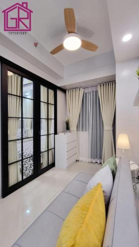 un soggiorno con un divano e un ventilatore a soffitto di Stylish Modern Condo at Shore Residences MOA a Manila