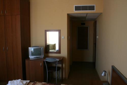Zimmer mit einem TV und einem Schreibtisch mit Stuhl in der Unterkunft Sofia Family Hotel in Pomorie