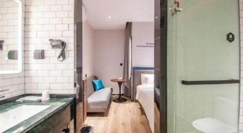 a bathroom with a tub and a sink and a chair at City Comfort Premier Hotel Liuzhou Wuxing Pedestrian Street Jinggu Building in Liuzhou