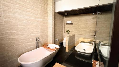 a bathroom with a tub and a toilet and a sink at Del Cielo Villa Jimbaran in Jimbaran