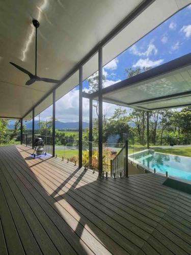 a house with a deck with a pool and large windows at Daintree Getaway - Private Oasis in Daintree