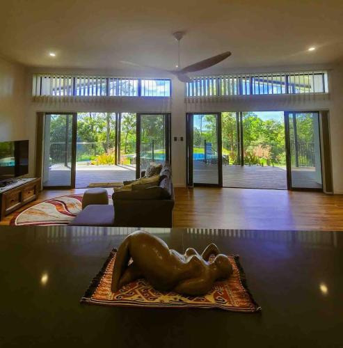 a living room with a woman laying on a table at Daintree Getaway - Private Oasis in Daintree
