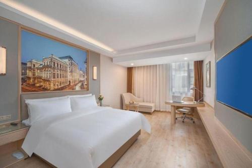 a bedroom with a large white bed and a large window at Vienna Hotel Yuxi Hongta Avenue High-Speed Railway Station in Yuxi