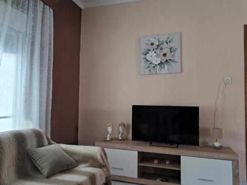 a living room with a television and a couch at Chris Apartment in Mélissa