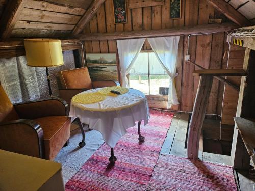 MaakeskiにあるRomantic countryside SAUNA Cottageのテーブルとソファ、窓が備わる客室です。