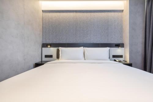a bedroom with a large bed with white sheets at Atour Light Hotel Beijing Zhongguancun Renmin University in Beijing