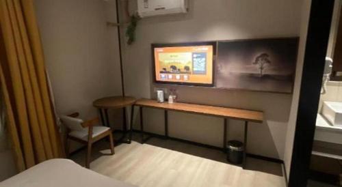 a small room with a desk and a chair at JTOUR Inn Wuhan Textile University in Wuhan