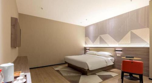 a bedroom with a bed and a table in it at Borrman Hotel Korla Peacock River in Korla