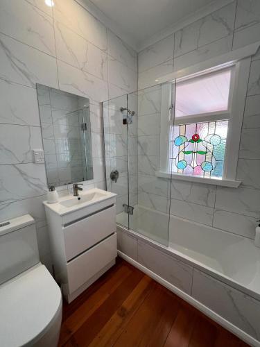 a bathroom with a sink and a shower and a window at Sackville Retreat in Martinborough 