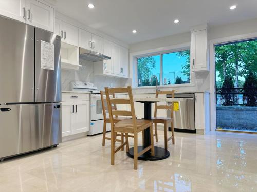 a kitchen with a table and chairs and a refrigerator at A Beautiful, cozy second floor room for staying in Vancouver