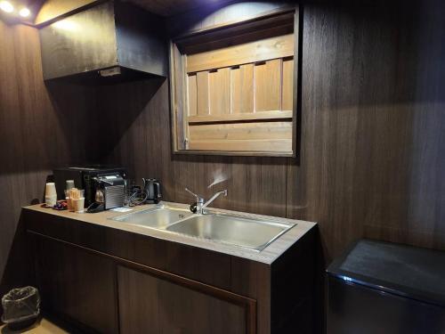 a kitchen with a sink and a microwave at Miyama Resort Kayabuki-tei - Matsuba's Inn in Nantan city