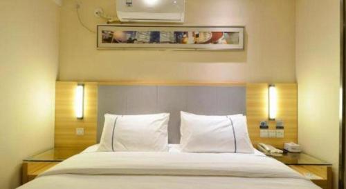 a bedroom with a large bed with two pillows at City Comfort Inn Hotel Wuhan Optics Valley Square Metro Station Zhongnan Minzu University in Wuhan