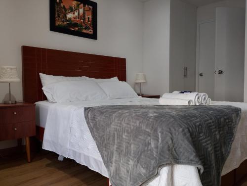a bedroom with a large bed with white sheets at Departamento Pardo Miraflores in Lima