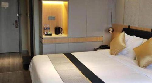 a bedroom with a large white bed with a window at City Comfort Inn Hotel Wuhan Optics Valley Square Metro Station Zhongnan Minzu University in Wuhan