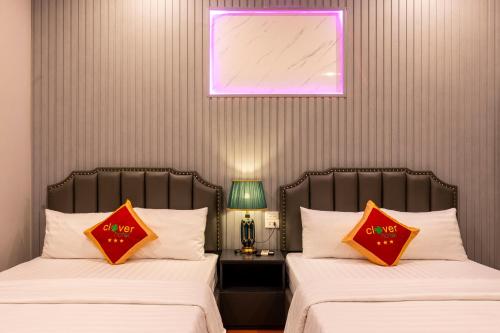 two beds sitting next to each other in a room at Clover Hanoi Hotel - City Center in Hanoi