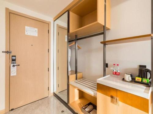 un armario en una cocina con una puerta abierta en GreenTree Eastern Hotel Tianjin Dongli Development Zone Xinli Metro Station, en Tianjin
