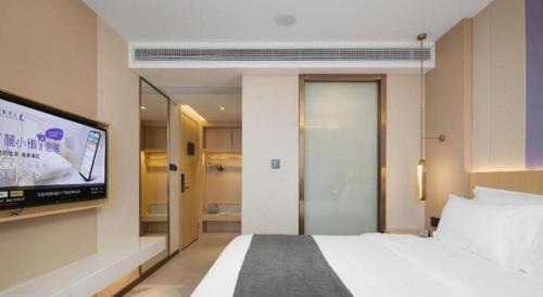 a bedroom with a bed and a flat screen tv at Lavande Hotel Guangzhou Quzhuang Metro Station in Guangzhou