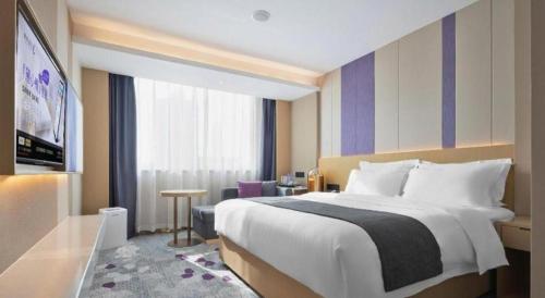 a hotel room with a large bed and a desk at Lavande Hotel Guangzhou Quzhuang Metro Station in Guangzhou
