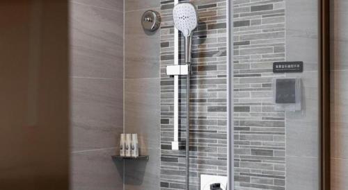 a shower with a glass door in a bathroom at Lavande Hotel Guangzhou Quzhuang Metro Station in Guangzhou