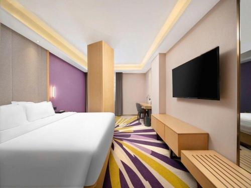 a hotel room with a bed and a flat screen tv at Lavande Hotel Changchun Gaoxin Jilin University in Changchun