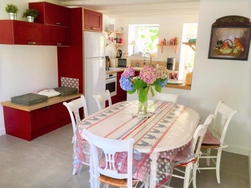 une cuisine avec une table avec un vase de fleurs dessus dans l'établissement Gîte de charme proche Rance 4 étoiles 3 Chambres, à Le Minihic-sur-Rance