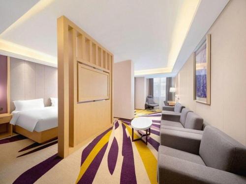 a hotel room with a bed and couches and a bed and a couch at Lavande Hotel Changchun Gaoxin Jilin University in Changchun