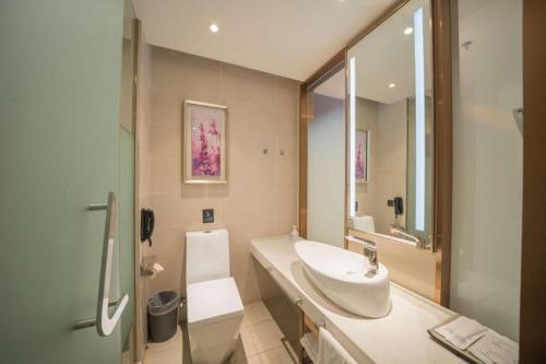 a bathroom with a sink and a toilet and a mirror at Lavande Hotel Changchun Gaoxin Jilin University in Changchun