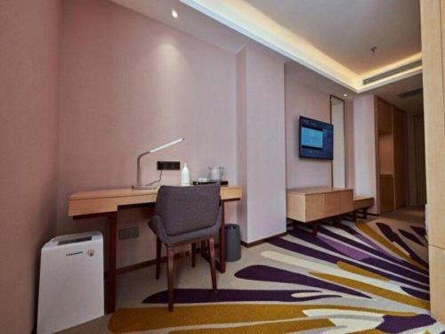 a room with a desk with a chair and a television at Lavande Hotel Changchun Gaoxin Jilin University in Changchun