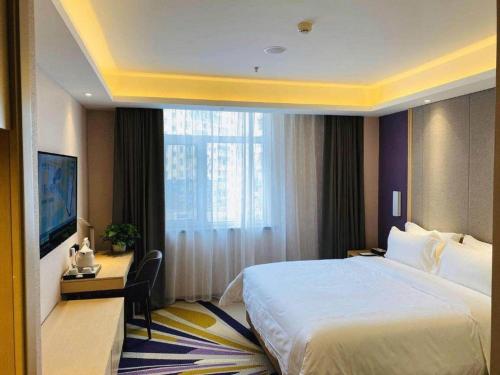 a hotel room with a large bed and a desk at Lavande Hotel Changchun Gaoxin Jilin University in Changchun
