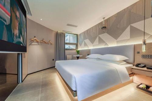 a bedroom with a large white bed and a tv at Borrman Hotel Chongqing Bishan Central Street in Chongqing