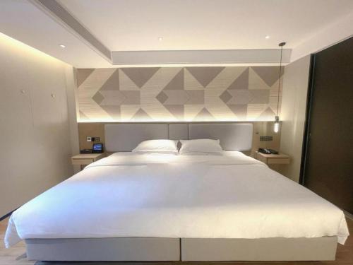 a bedroom with a large white bed in a room at Borrman Hotel Chongqing Bishan Central Street in Chongqing
