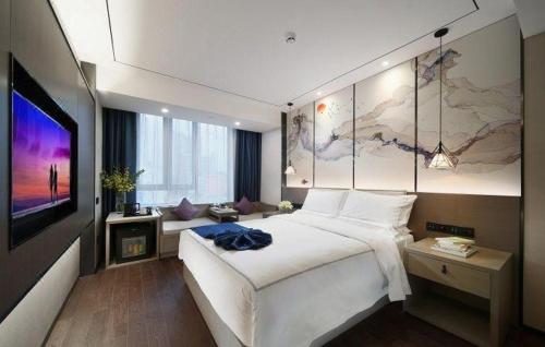 a bedroom with a large white bed and a tv at Xiamen Seashine Lakeview Hotel in Xiamen