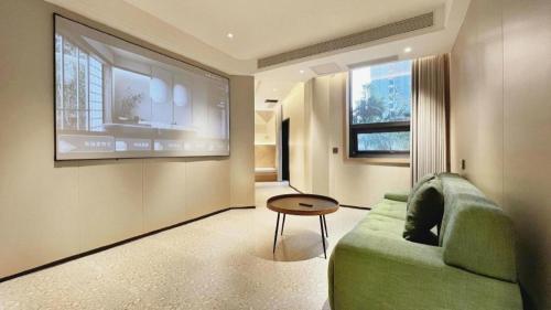 a living room with a green couch and a table at Borrman Hotel Chongqing Bishan Central Street in Chongqing