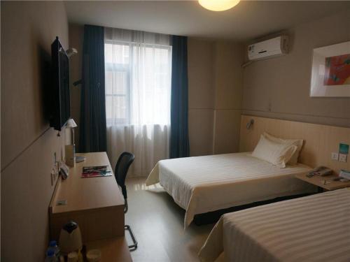 a hotel room with two beds and a window at Jinjiang Inn Shenzhen Airport in Shenzhen