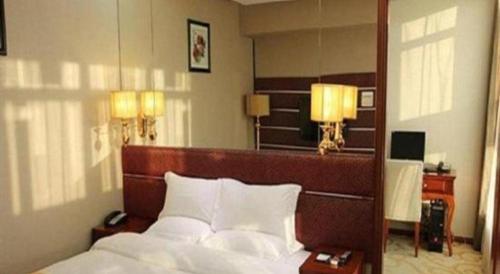 a bedroom with a large bed and two lamps at Milu Hotel in Guangzhou