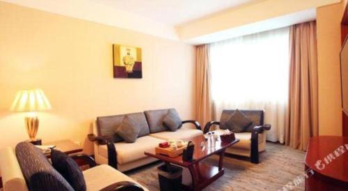 a living room with a couch and a table at Xiamen Jingmin Central Hotel in Xiamen