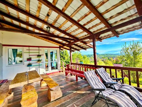 a patio with a table and chairs on a deck at Casa De Sub Padure in Bran